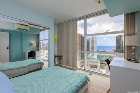 a bedroom with a balcony a bed and a large window