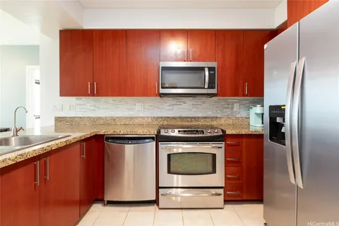 a kitchen with stainless steel appliances granite countertop a stove microwave and refrigerator