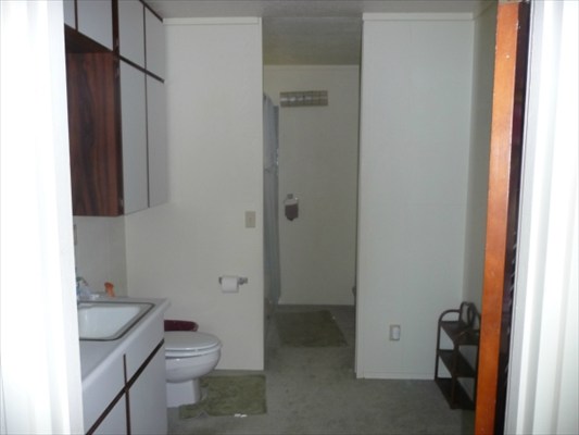 82-6061 Captain Cook Village Road Captain Cook, HI 96704 - Photo 11 of 16 a bathroom with a granite countertop toilet a sink and a mirror
