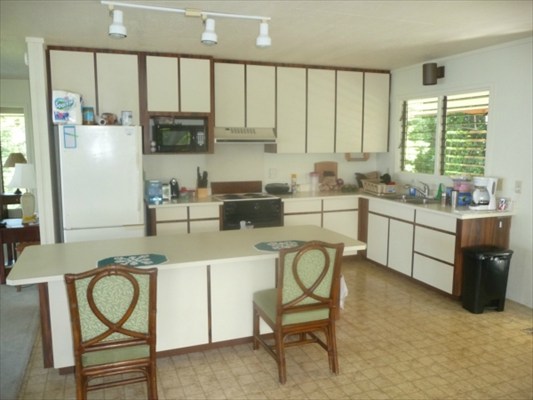 82-6061 Captain Cook Village Road Captain Cook, HI 96704 - Photo 12 of 16 a kitchen with stainless steel appliances a stove a sink and cabinets