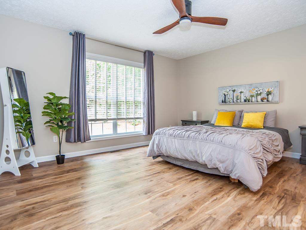 4900 Raytown Road Raleigh, NC 27613 - Photo 14 of 34 a bedroom with a bed and wooden floor