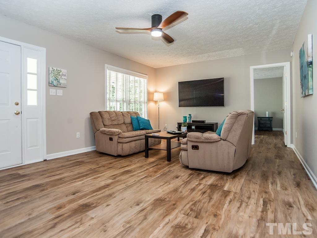 4900 Raytown Road Raleigh, NC 27613 - Photo 5 of 34 a living room with furniture and a flat screen tv
