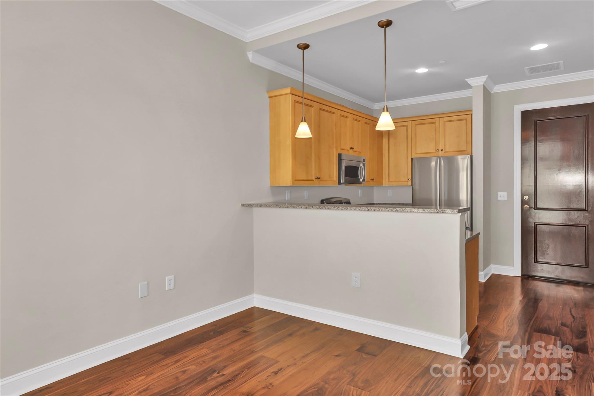 230 South Tryon Street, Unit 603 Charlotte, NC 28281 - Photo 26 of 32 a view of a refrigerator in kitchen and wooden floor