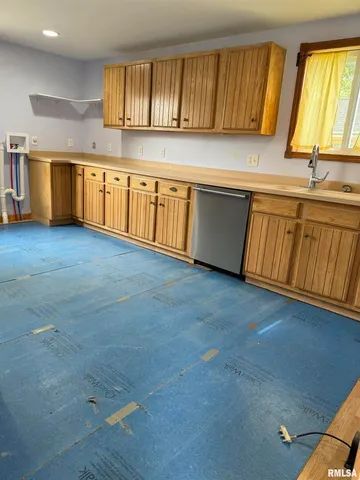 a kitchen with stainless steel appliances granite countertop a sink a stove cabinets and wooden floor