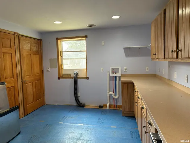a view of a kitchen with fridge and wooden floor