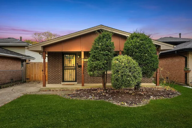 a backyard of a house with plants and large tree