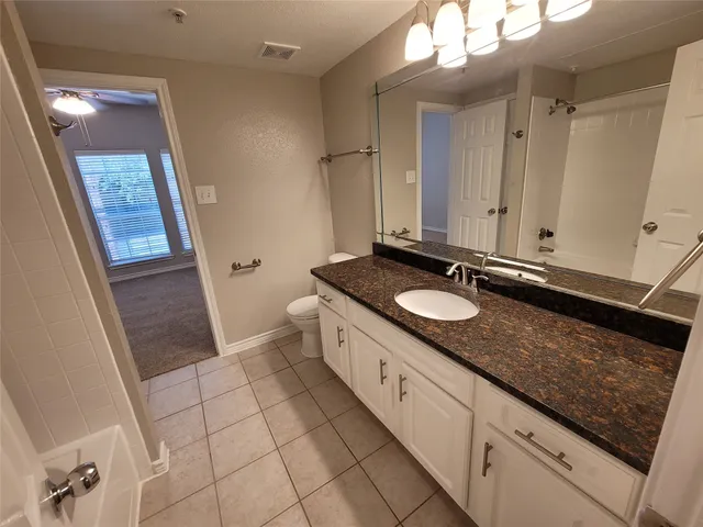 a spacious bathroom with a granite countertop sink and a mirror