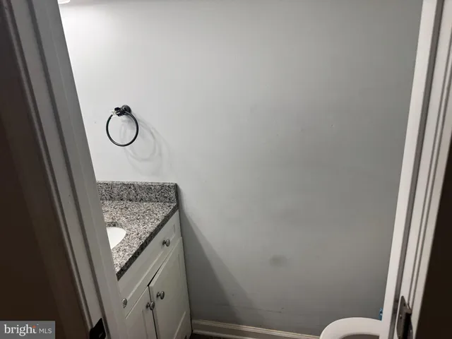 a bathroom with a granite countertop toilet and a sink