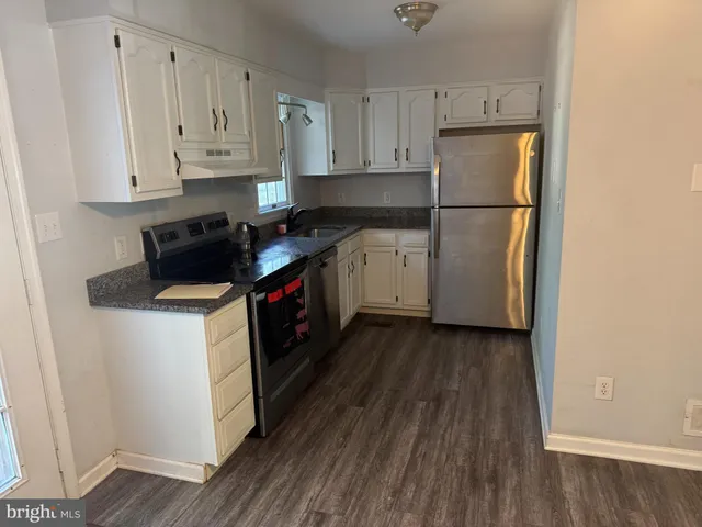 a kitchen with a refrigerator sink and cabinets