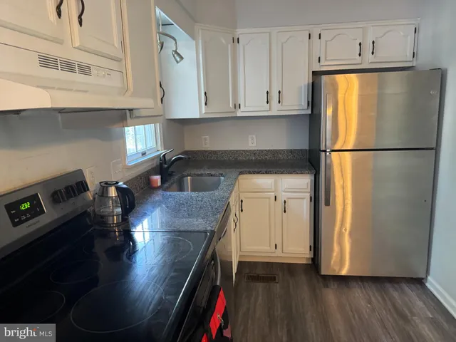 a kitchen with stainless steel appliances a refrigerator a sink a stove and cabinets
