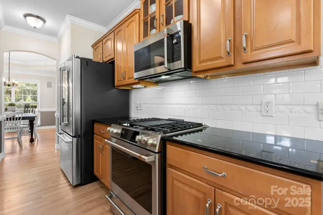 a kitchen with stainless steel appliances granite countertop a stove and a microwave