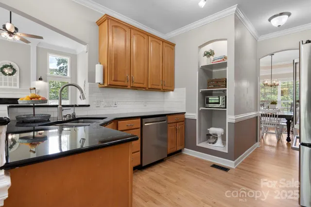 a kitchen with stainless steel appliances granite countertop a sink stove and cabinets
