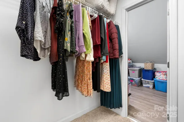 a view of walk in closet with clothes and shoes