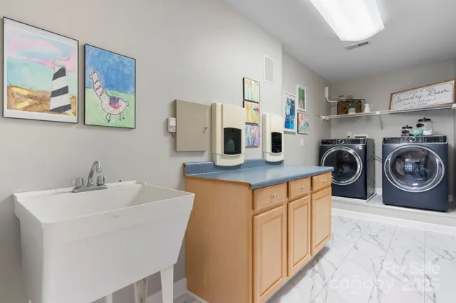 a utility room with sink dryer and washer