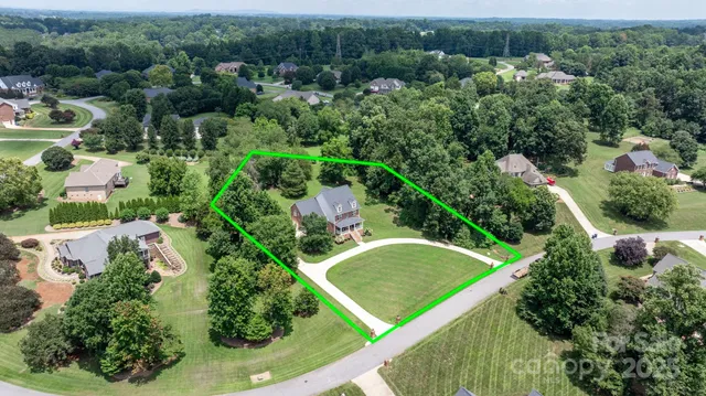an aerial view of residential houses with outdoor space and trees