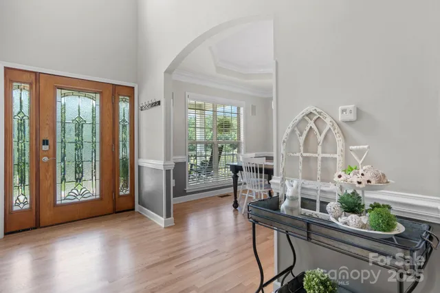 a living room with furniture large window and wooden floor