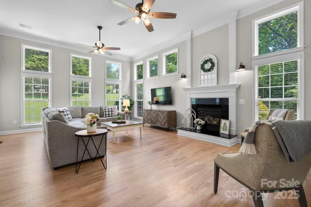 a living room with fireplace furniture and a large window