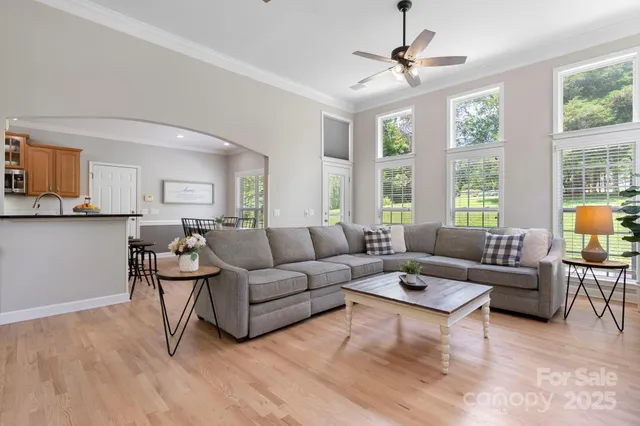 a living room with furniture a large window and a chandelier