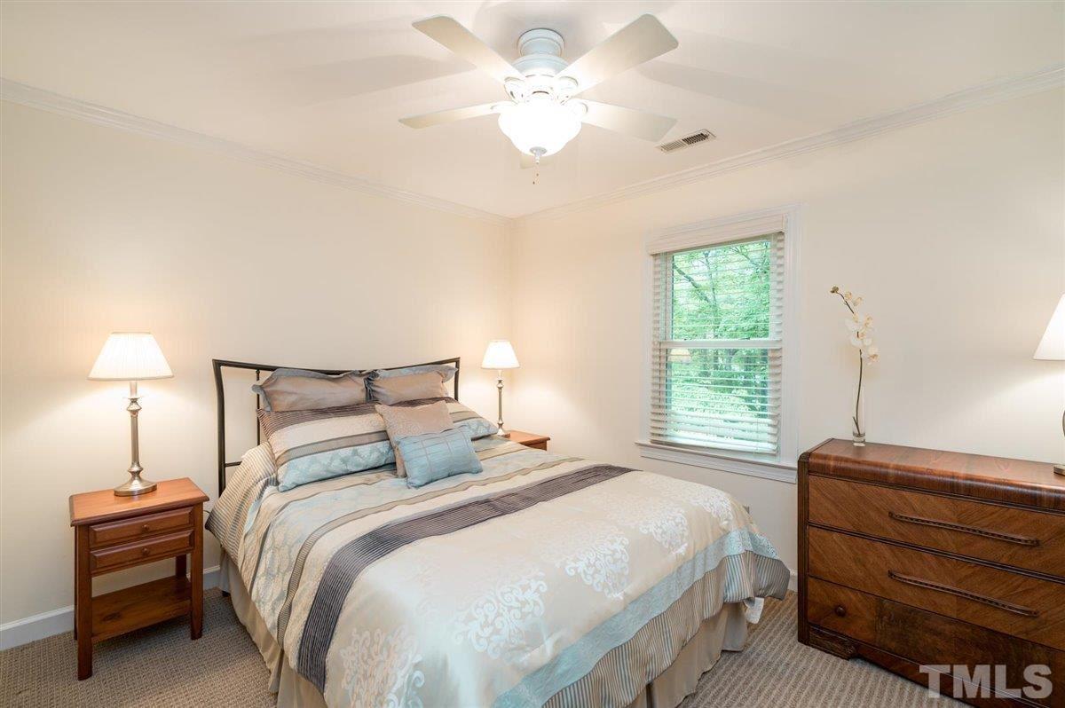 7916 Sutterton Court Raleigh, NC 27615 - Photo 15 of 25 a bedroom with a bed and a chandelier
