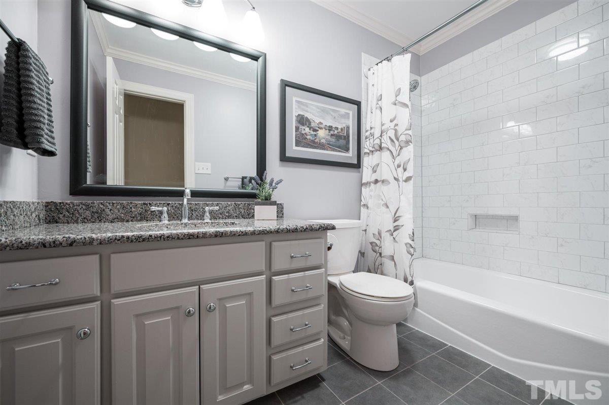 7916 Sutterton Court Raleigh, NC 27615 - Photo 18 of 25 a bathroom with a granite countertop sink toilet and shower