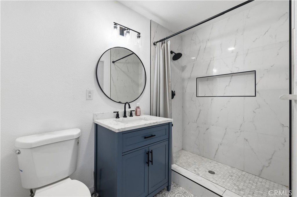 44335 Glenraven Road Lancaster, CA 93535 - Photo 20 of 32 a bathroom with a toilet a sink and a mirror
