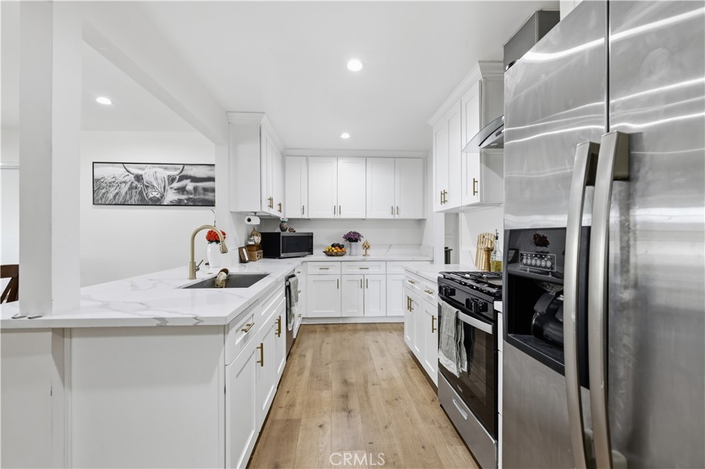 44335 Glenraven Road Lancaster, CA 93535 - Photo 8 of 32 a kitchen with a refrigerator and a sink