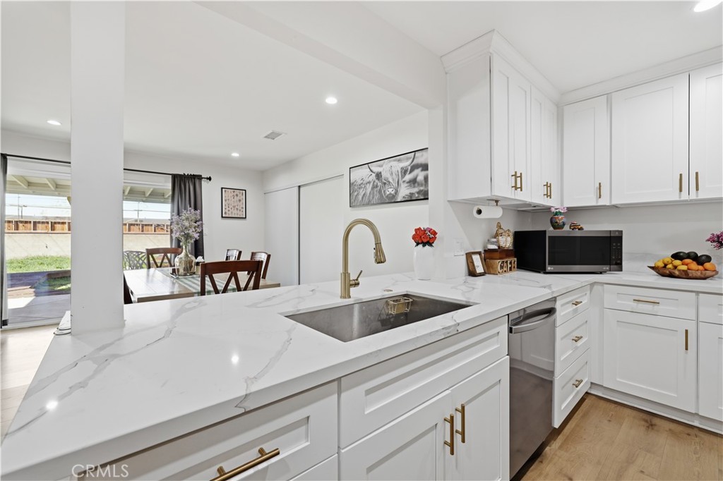 44335 Glenraven Road Lancaster, CA 93535 - Photo 9 of 32 a kitchen with white cabinets a sink and white stainless steel appliances
