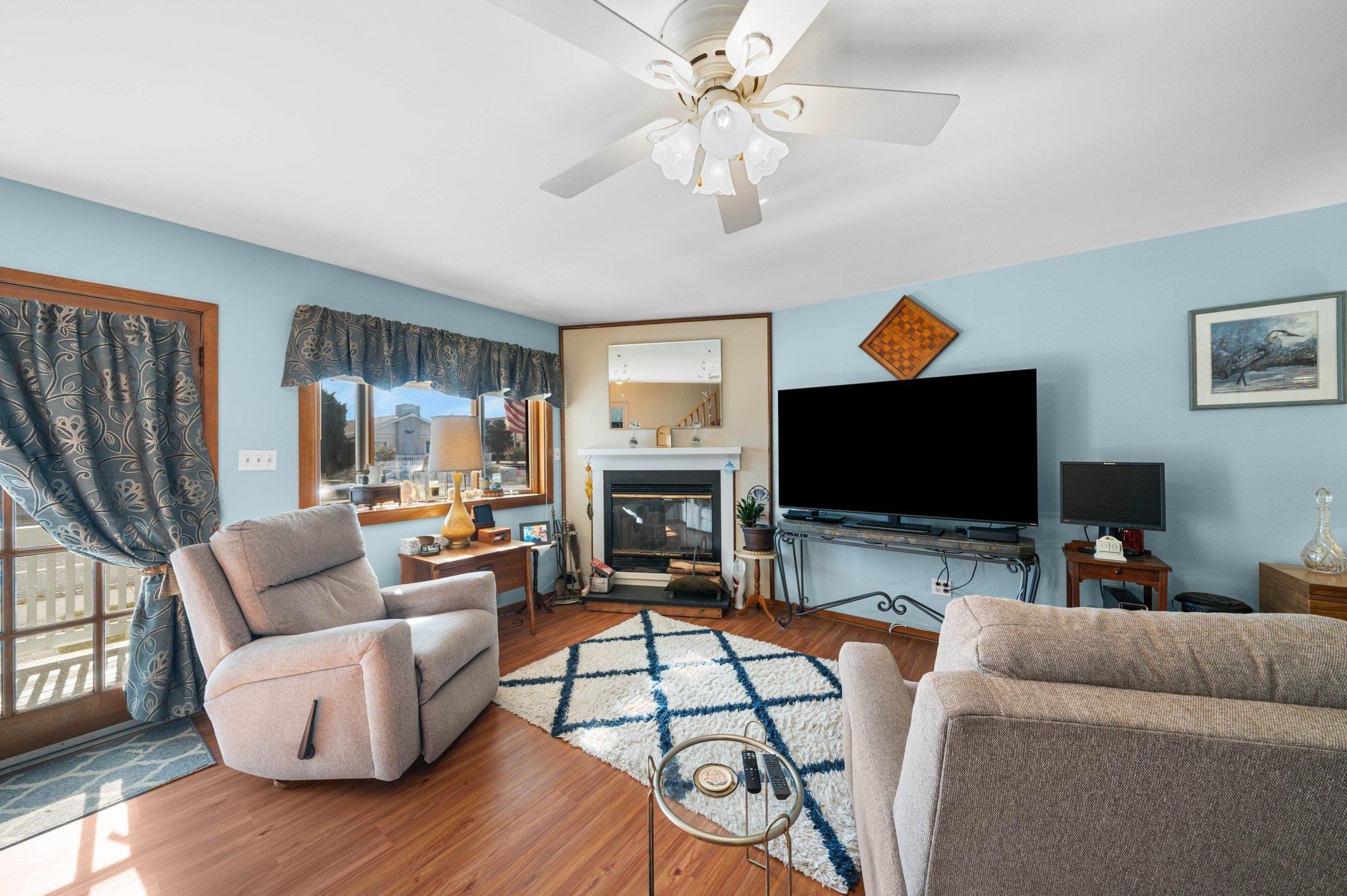 2754 1st Avalon, NJ 08202 - Photo 3 of 26 a living room with furniture a flat screen tv and a fireplace