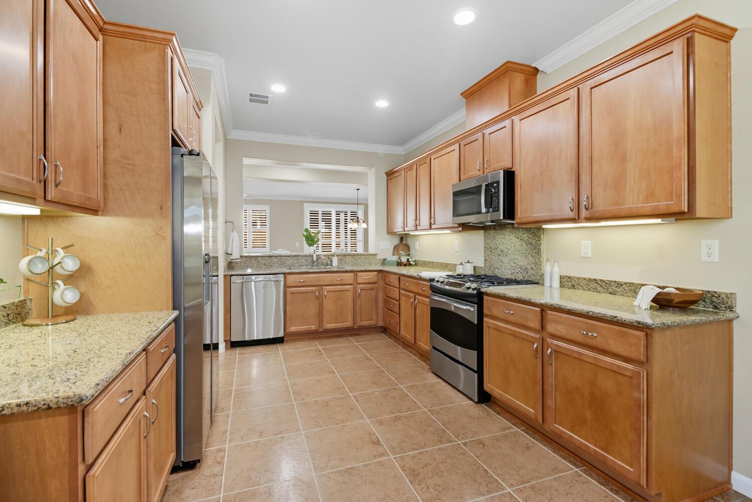 7409 Rothschild Court Elk Grove, CA 95757 - Photo 17 of 62 a kitchen with stainless steel appliances granite countertop a sink counter space cabinets and a stove