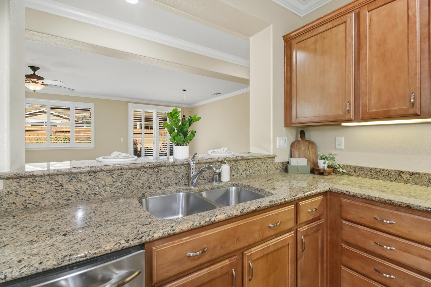 7409 Rothschild Court Elk Grove, CA 95757 - Photo 20 of 62 a kitchen with granite countertop a sink a window and cabinets