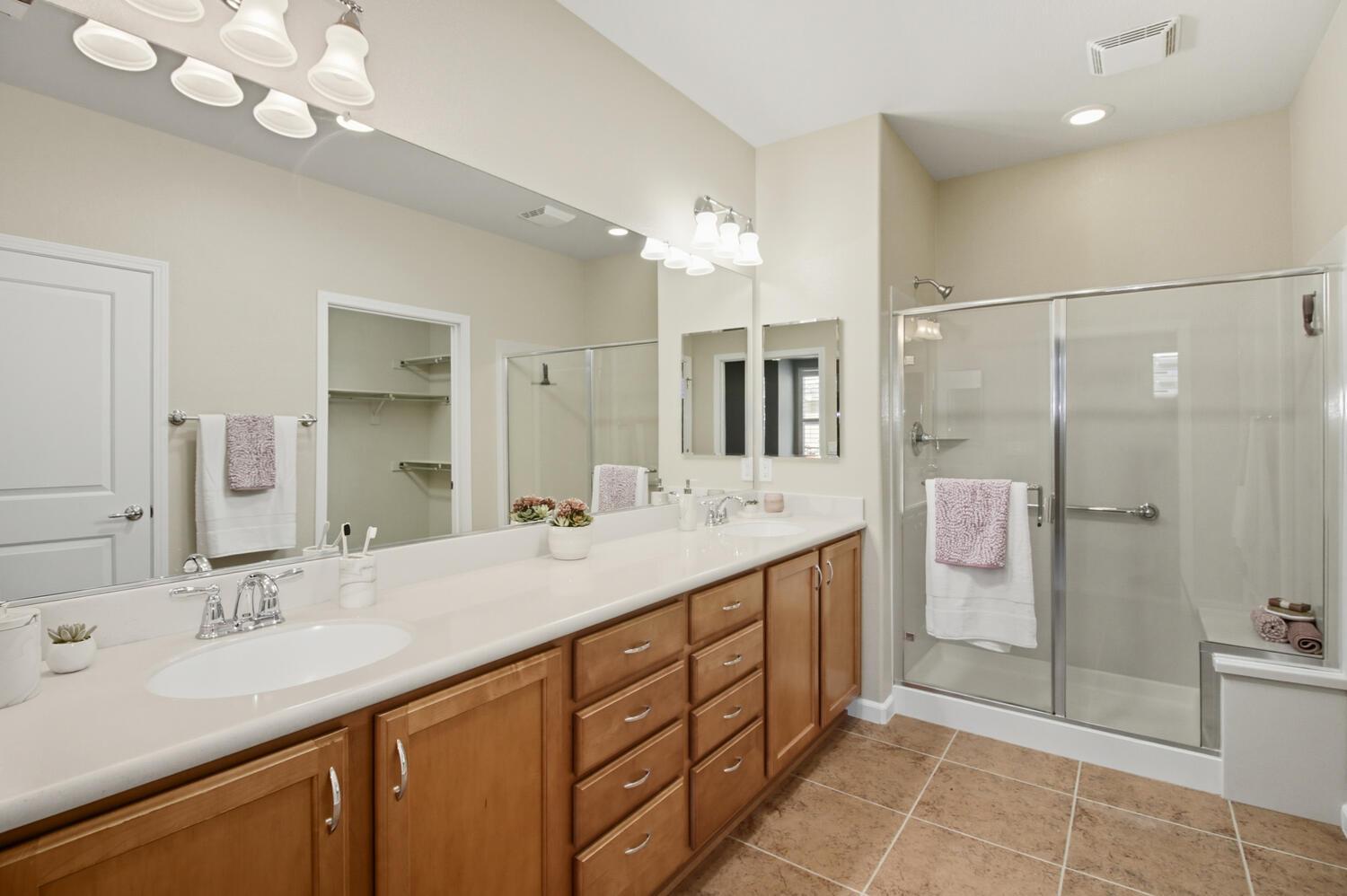 7409 Rothschild Court Elk Grove, CA 95757 - Photo 25 of 62 a bathroom with a double vanity sink mirror and shower