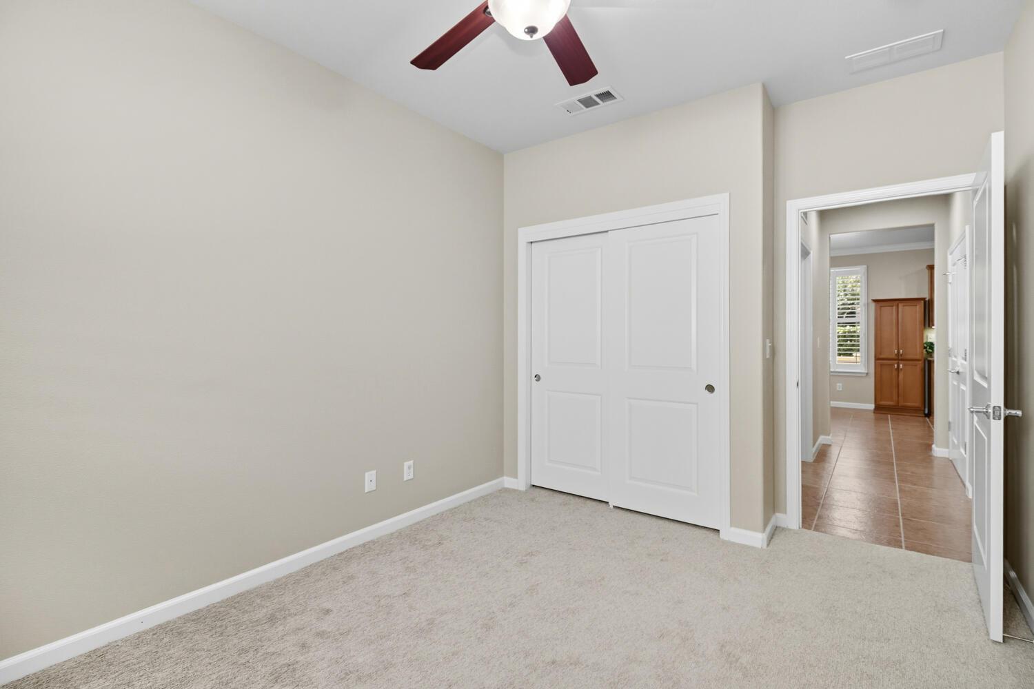 7409 Rothschild Court Elk Grove, CA 95757 - Photo 29 of 62 an empty room with closet and a chandelier fan