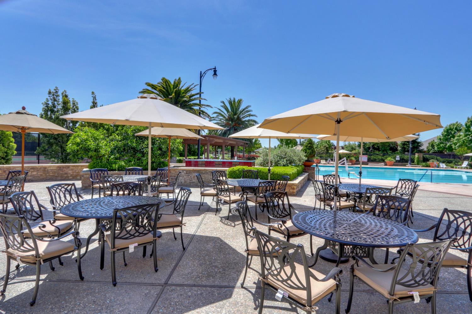 7409 Rothschild Court Elk Grove, CA 95757 - Photo 53 of 62 a view of patio with chairs and table under an umbrella with a barbeque