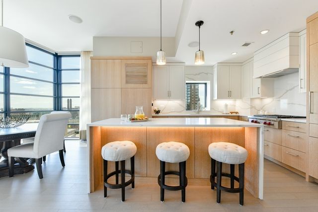 a dining table chairs kitchen island and stainless steel appliances