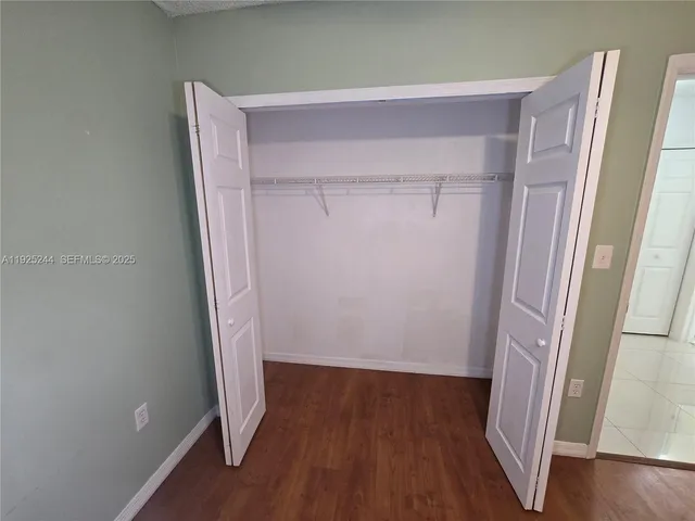 a view of an empty room with a chandelier fan