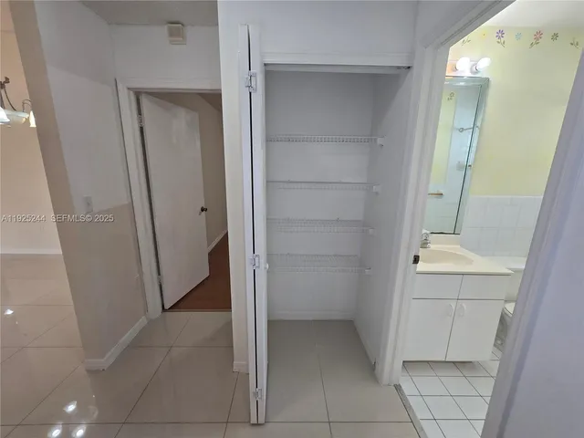 a view of a livingroom with a chandelier fan and wooden floor