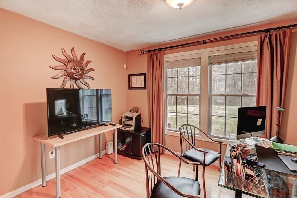 97 Weldon Farm Road Rowley, MA 01969 - Photo 14 of 37 a living room with furniture a flat screen tv and a floor to ceiling window