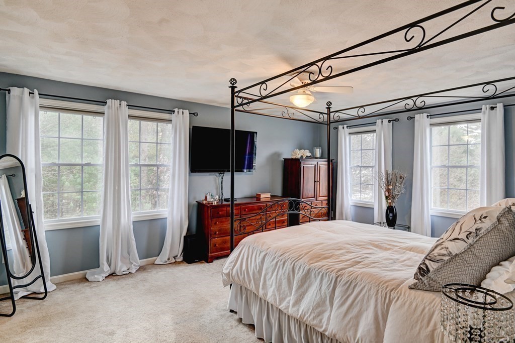 97 Weldon Farm Road Rowley, MA 01969 - Photo 23 of 37 a bedroom with a bed flat screen tv and a large window