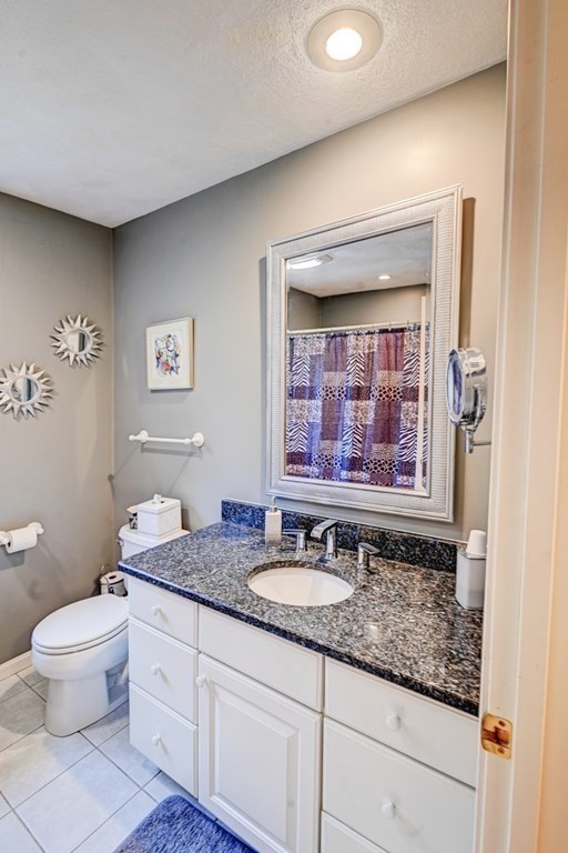 97 Weldon Farm Road Rowley, MA 01969 - Photo 29 of 37 a bathroom with a granite countertop sink mirror vanity and toilet
