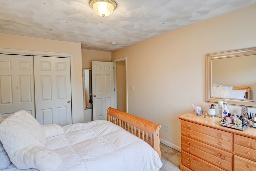 97 Weldon Farm Road Rowley, MA 01969 - Photo 31 of 37 a bedroom with a bed and a mirror on dresser