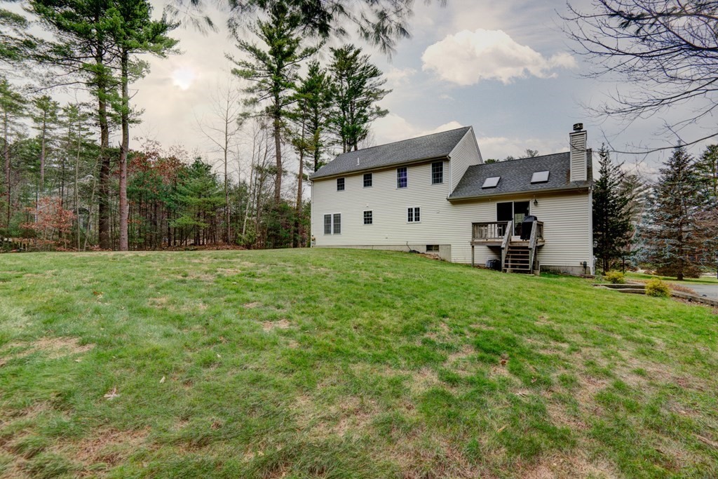 97 Weldon Farm Road Rowley, MA 01969 - Photo 5 of 37 a front view of a house with a garden and trees