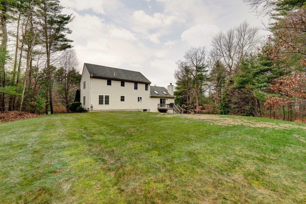 97 Weldon Farm Road Rowley, MA 01969 - Photo 6 of 37 a view of a white house in front of a big yard with plants and large trees