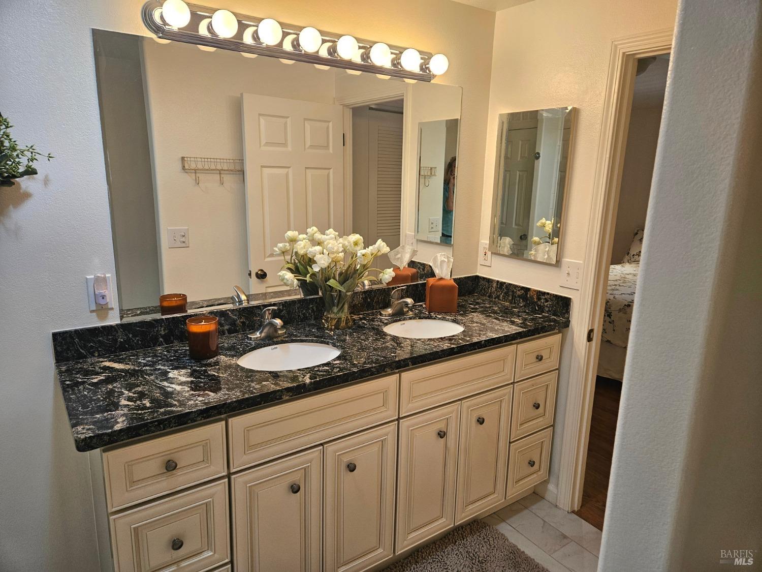 2 San Ardo Court St. Helena, CA 94574 - Photo 14 of 45 a bathroom with a granite countertop sink and a mirror