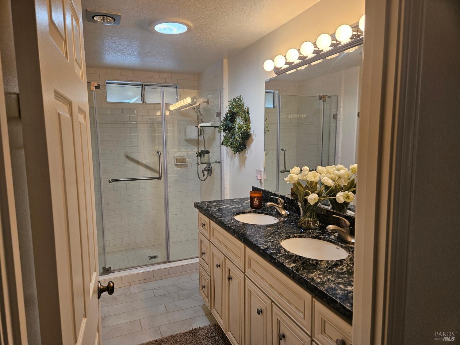 2 San Ardo Court St. Helena, CA 94574 - Photo 15 of 45 a bathroom with a granite countertop sink a shower and a mirror