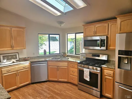 a kitchen with a sink stove top oven and refrigerator