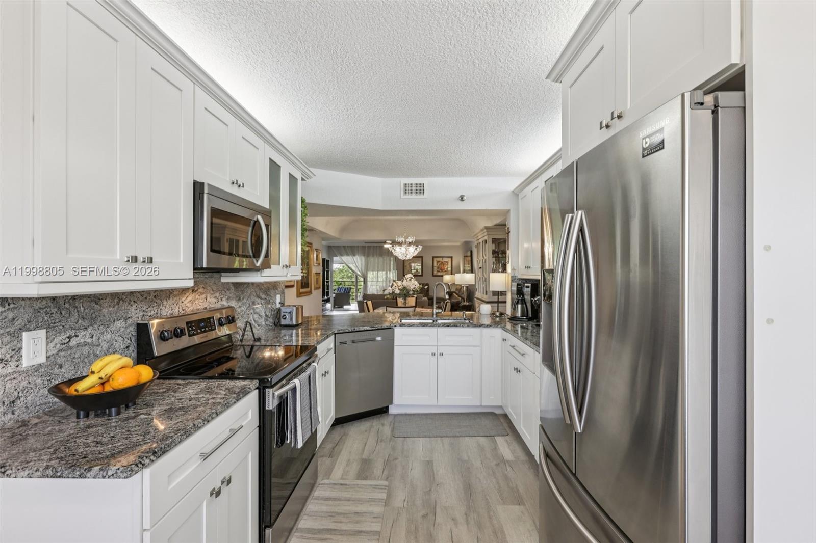 a kitchen with stainless steel appliances granite countertop a refrigerator a stove a sink a microwave and cabinets