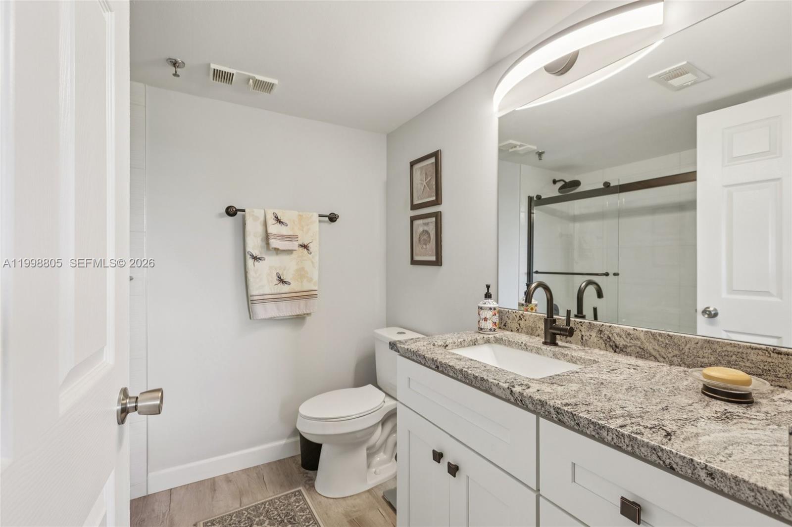 9170 Southwest 14th Street, Unit 4508 Boca Raton, FL 33428 - Photo 5 of 48 a bathroom with a granite countertop sink toilet and a mirror