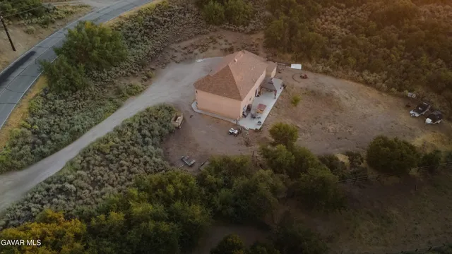 an aerial view of residential houses with outdoor space and trees