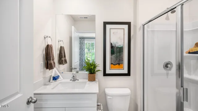 a bathroom with a sink vanity mirror and toilet