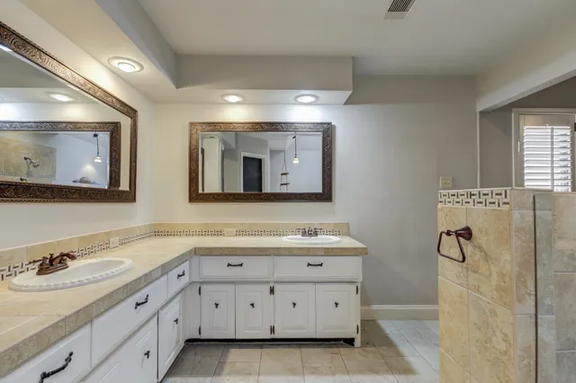 a bathroom with a double vanity sink and mirror